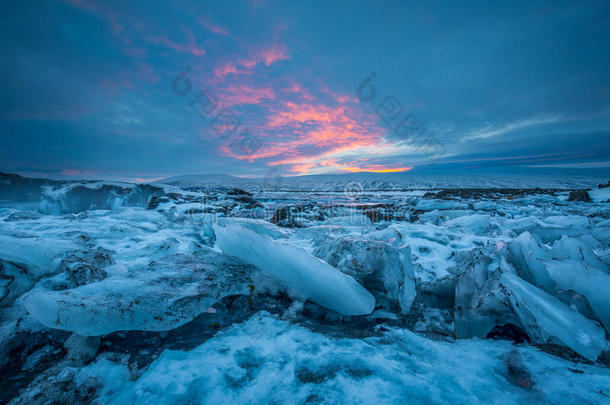 在瀑布附近的彩色日落天空下，可以看到<strong>泛舟</strong>的浮冰。