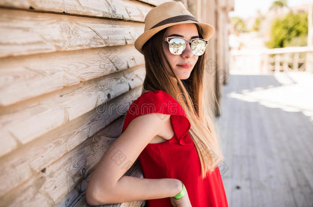 在避暑胜地，穿着红色连衣裙，戴着红色帽子的漂亮女<strong>模特</strong>。暑<strong>假</strong>。