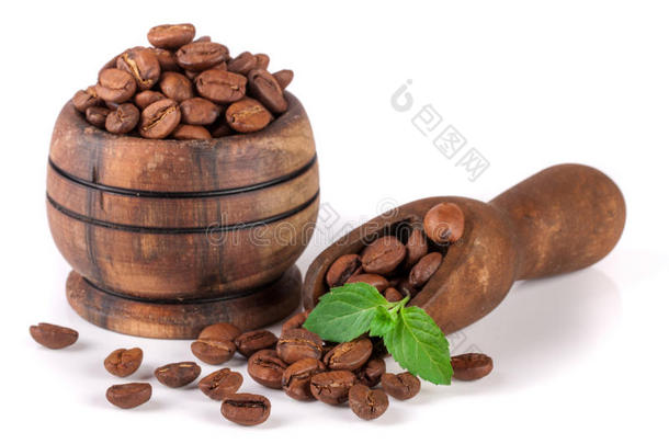 咖啡豆放在<strong>一个</strong>木碗里，<strong>勺子</strong>被隔离在白色的背景上