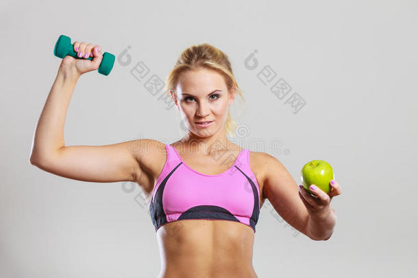 饮食适合身体。 女孩拿着<strong>哑铃</strong>和苹果水果