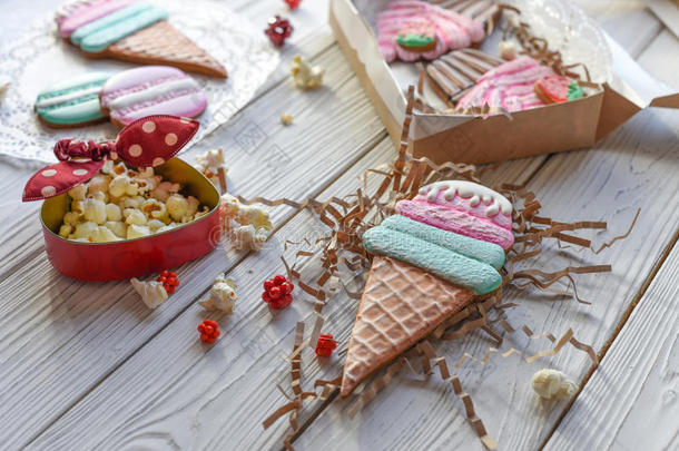 一张明亮的别针风格的照片与饼干形状的冰淇淋锥，马卡龙和纸杯蛋糕
