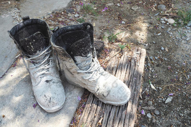 靴子弄脏了白色水泥。 放在旧木屑和水泥地板上。