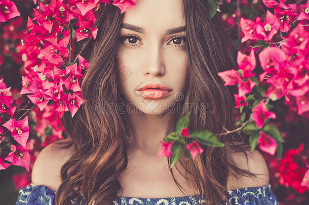 美丽的年轻女人被鲜花包围