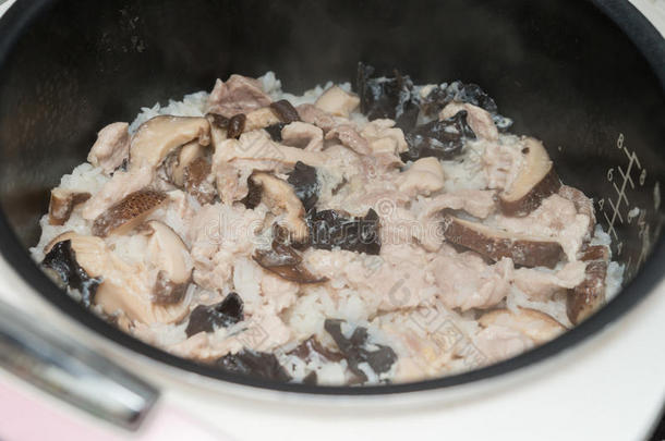 用电饭煲用猪肉蘑菇和黑木耳煮米饭