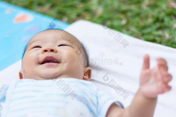 割亚洲婴儿躺在地上，满脸微笑