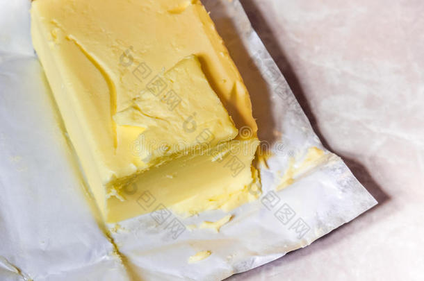 奶油黄油在它未包装的铝箔纸上。 在光桌上