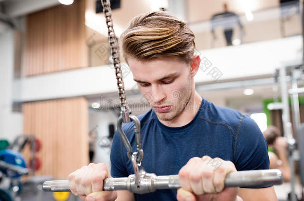 适合年轻人在健身房锻炼下拉机器。