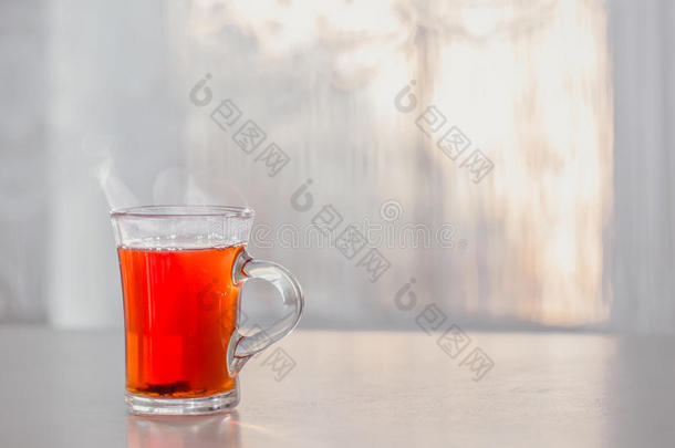 一杯热气腾腾的热茶放在靠窗的桌子上