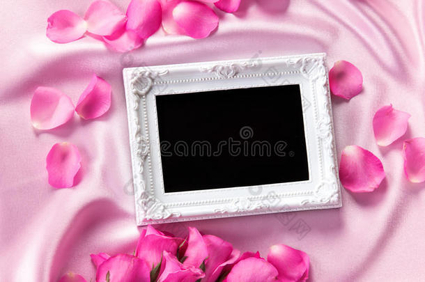 空相框，沙发上有一束甜美的粉红色玫瑰花瓣