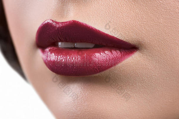特写一位涂着口红或唇膏的女人的嘴唇