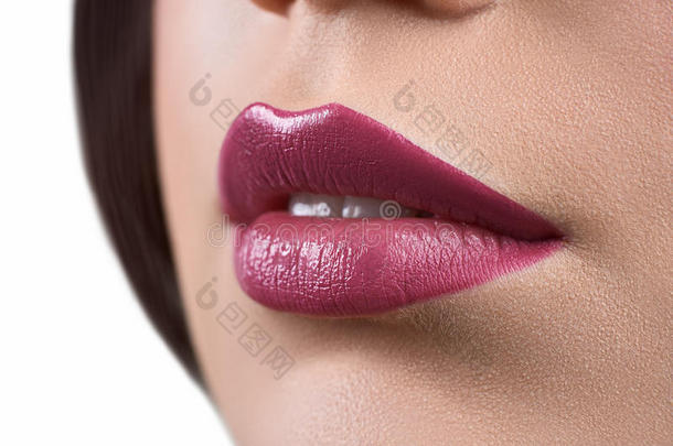 特写一位涂着口红或唇膏的女人的嘴唇
