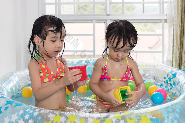 亚洲中国小姐妹在充气池里玩耍