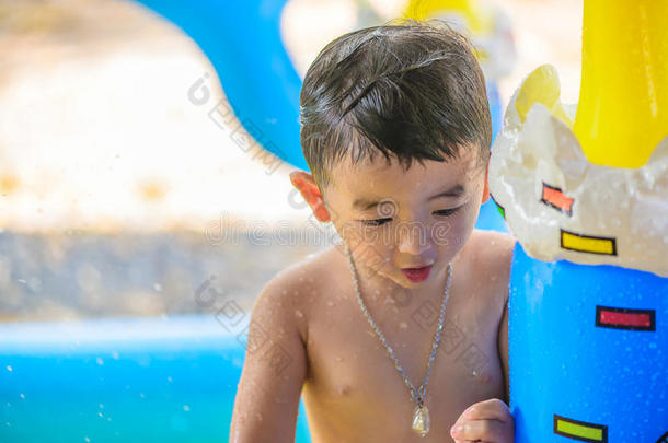 炎热的夏天，亚洲孩子在充气婴儿游泳池里玩耍