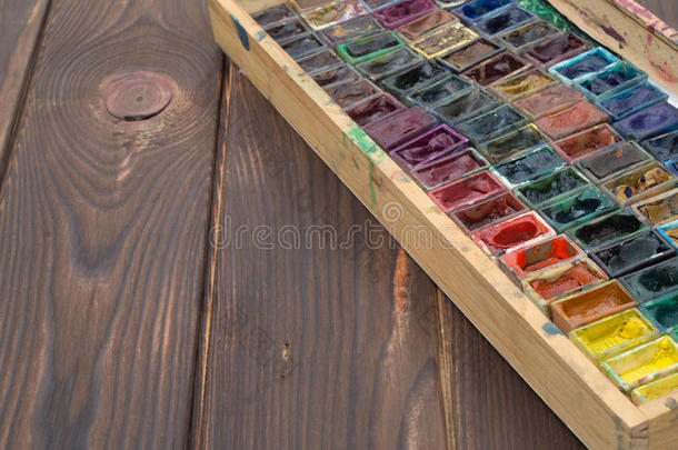 木制表面上有水彩和刷子的盒子