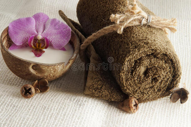 一条折叠的毛巾，用绳子和椰子汁中的兰花绑在一张轻薄的编织餐巾纸上，为水疗做准备