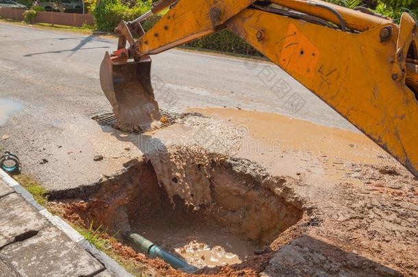 挖掘机在道路上修理管道下水管道