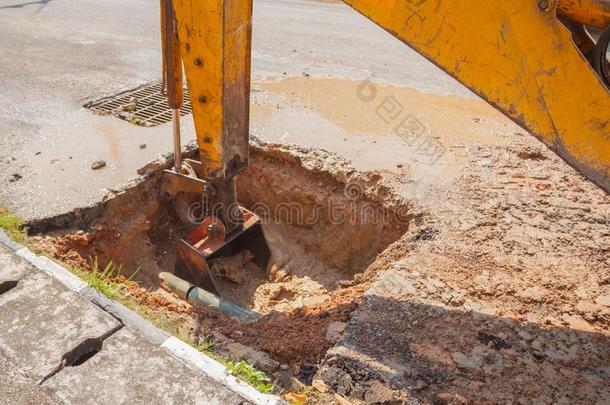 挖掘机在道路上修理管道下水管道