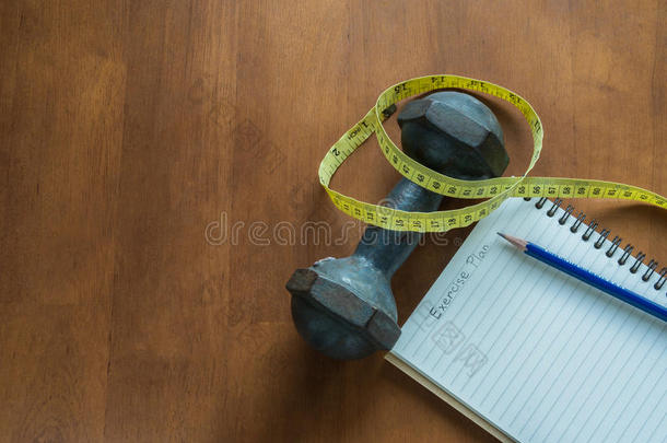 哑铃，测量磁带，铅笔和笔记本，表示锻炼