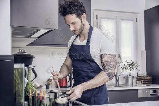 英俊的肌肉男在厨房做饭