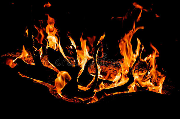 篝火，火焰舌头在晚上燃烧在黑色的背景上