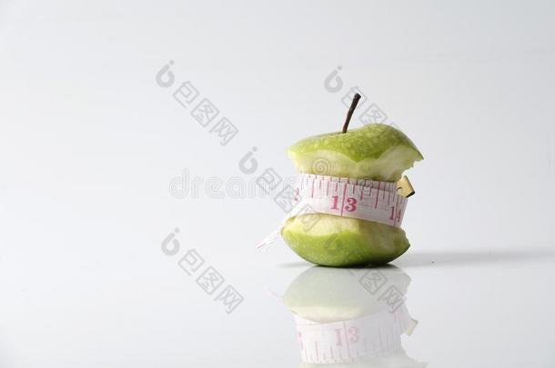 关闭绿色苹果与测量磁带隔离在白色背景。