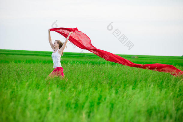 一位年轻女士拿着<strong>纸巾</strong>在绿地上奔跑。戴围巾的女人。
