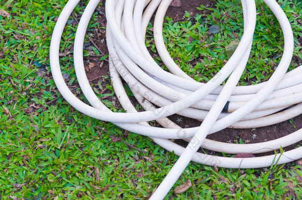 花园软管或白色橡胶管与水龙头在草地上。