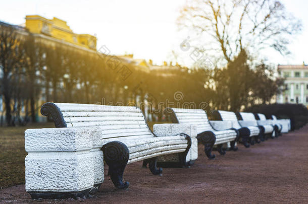 公园里经典的白色长椅，阳光明媚