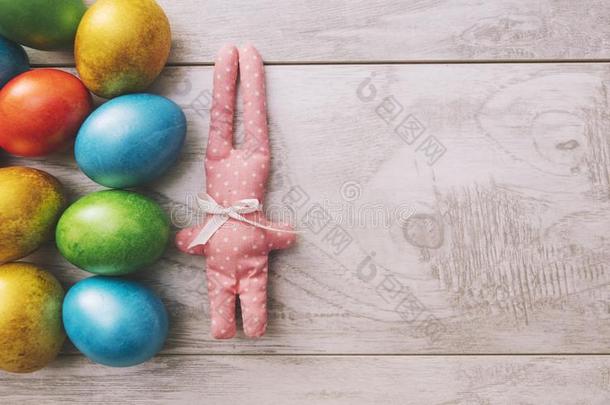 五颜六色的复活节假期鸡蛋闪闪发光，玩具兔子