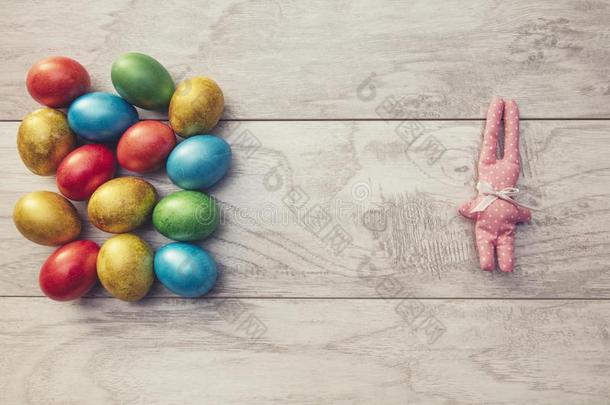 五颜六色的复活节假期鸡蛋闪闪发光，玩具兔子