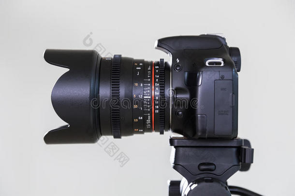 数字SLR相机与可互换的手动镜头在灰色背景。 在内部射击。 电影制作的设备