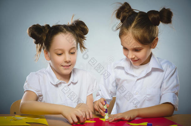 女孩们用胶水和剪刀用彩色纸做一些事情