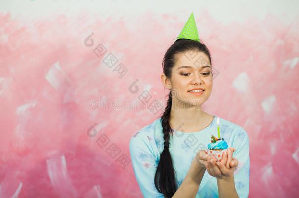 美丽的年轻女人拿着生日蛋糕和<strong>许愿</strong>