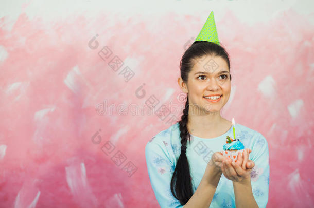 美丽的年轻女人拿着生日蛋糕和许愿