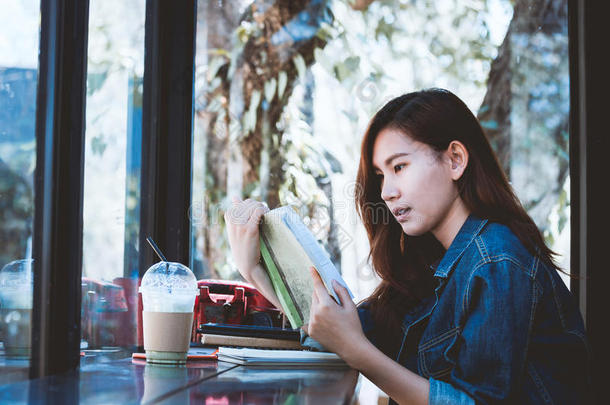 亚洲十几岁的孩子独自坐在咖啡吧里看书。