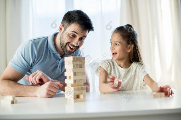 <strong>欢快</strong>的父亲和女儿在家里玩Jenga<strong>游戏</strong>