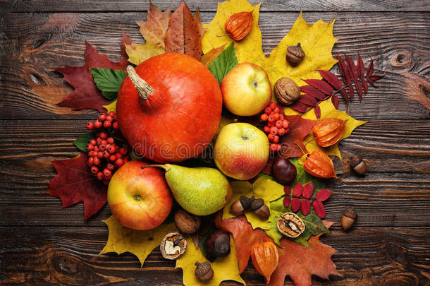 秋天的静物，收获的南瓜带着落叶和秋天的果实，秋天的礼物，木制的背景，核桃，枫树的离开