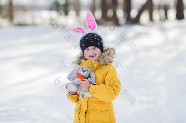 可爱的小女孩和兔子兔子有一个复活节在白雪背景
