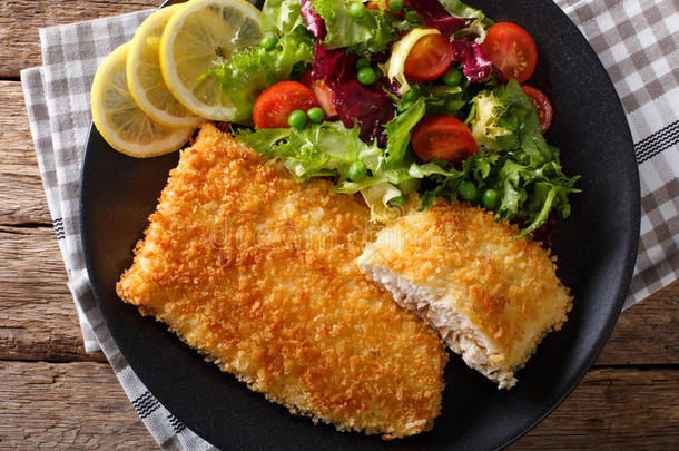 油炸鱼片面包和新鲜蔬菜沙拉特写。 水平顶部视图