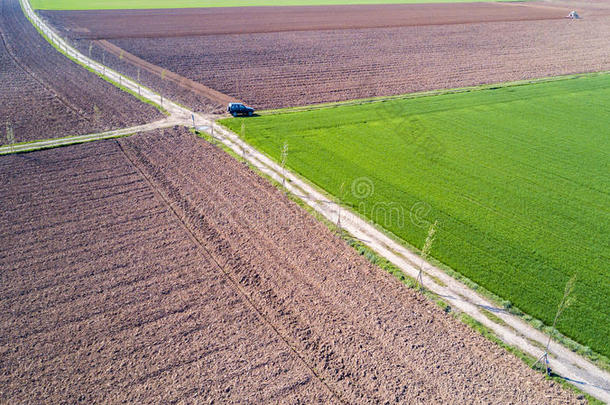 一辆<strong>吉普车</strong>穿过乡村公路，从路边的空中看到一辆汽车穿过田野的泥土路。