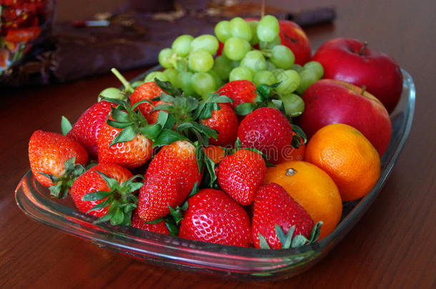 木制桌子上玻璃碗里的新鲜水果