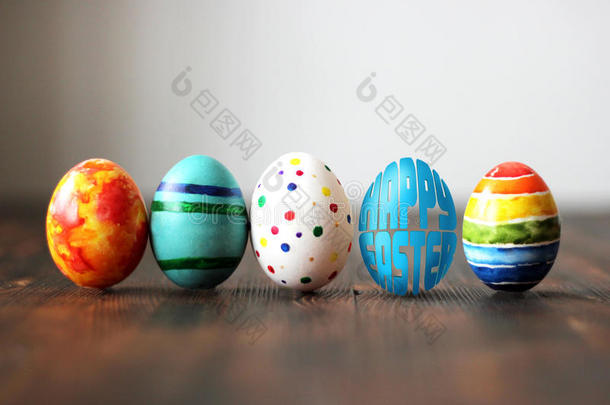 复活节彩色鸡蛋在木制背景与鸡蛋形状的单词快乐复活节。