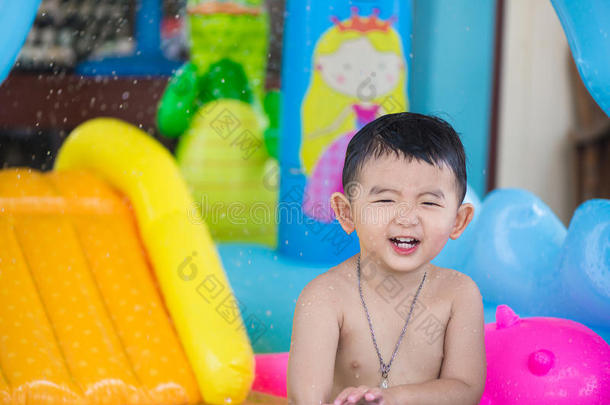 炎热的夏天，亚洲孩子在充气婴儿游泳池里玩耍
