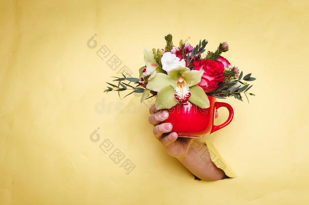 手拿着小花瓶，花和百合通过黄色的背景<strong>盈亏</strong>平衡