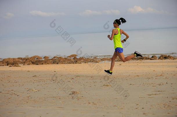 健身女子跑步者在海滩上跑步
