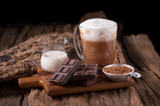木制背景上的冷巧克力牛奶饮料和巧克力棒