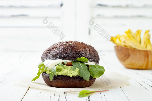 烤波托贝罗蘑菇汉堡。 素食，无麸质，无谷物，健康蔬菜汉堡与鳄梨酱，新鲜蔬菜