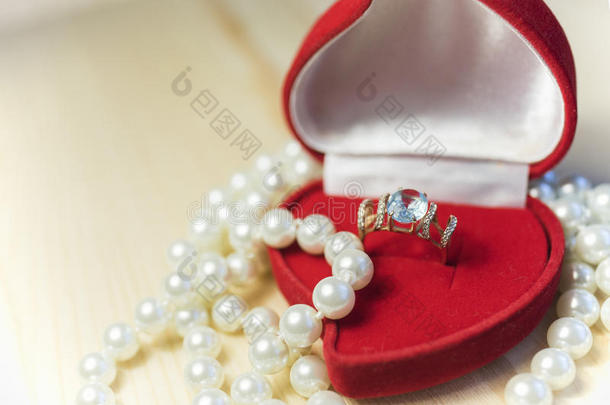 金色戒指，红色礼品盒里有宝石和珍珠