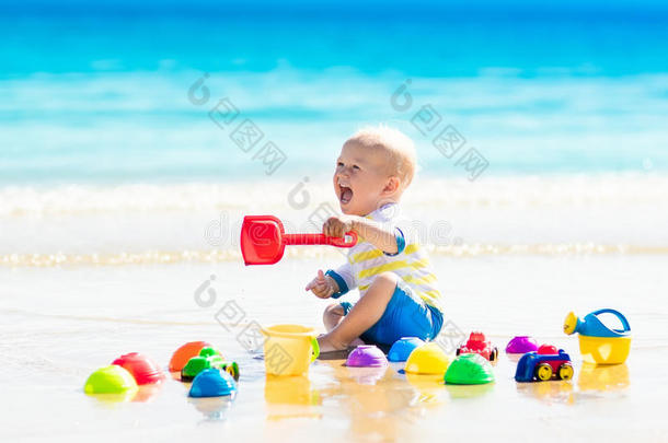 婴儿在热带海滩上玩耍，在沙滩上挖掘