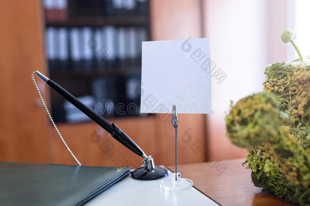 银行标签上的笔记持有人在桌子上，办公室在后台。 文字的位置。